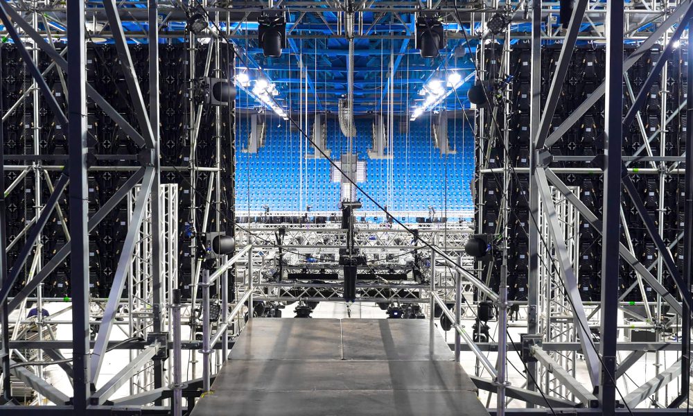 Installation of equipment and spotlights for stage. Stock footage. Preparing stage with bleachers and professional equipment and floodlights before performance or competition.